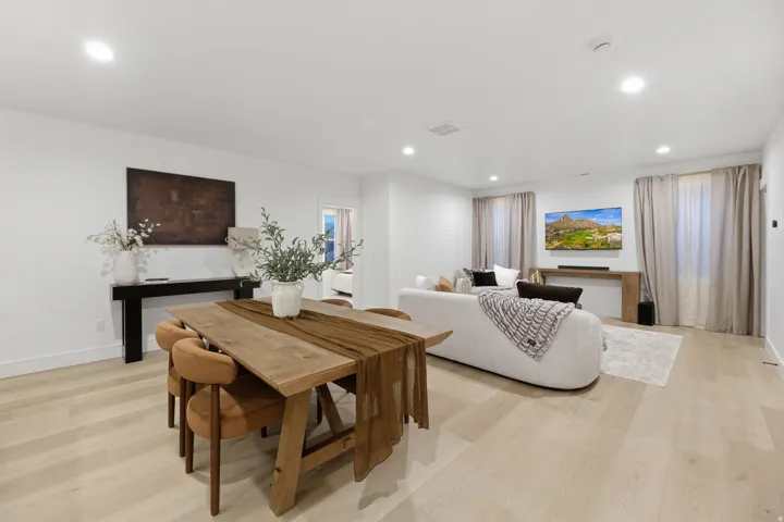 Recessed lighting, light wood-finish flooring, white walls, and substantial window treatments