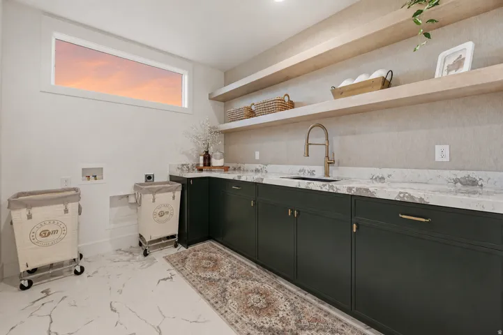 Built-in cabinetry with brass hardware, undermount sink, and light-toned countertops