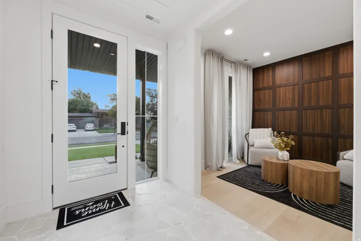 Dual glass-paneled entry doors, light-toned tile flooring, and a recessed ceiling