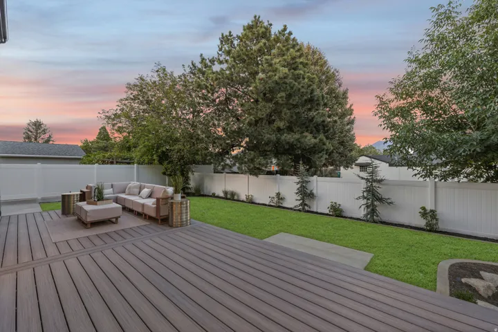 Spacious backyard featuring a composite deck, a manicured lawn, and a privacy fence