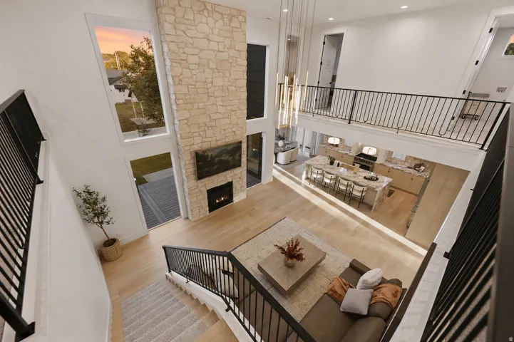 Two-story living area featuring a stone-clad fireplace and large windows