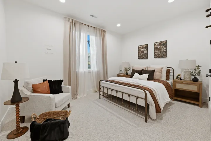 Recessed lighting illuminates the carpeted flooring and white walls