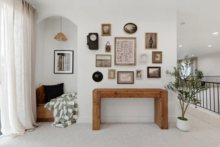 Built-in seating with storage, archway feature, recessed lighting, carpeted flooring, and metal railing