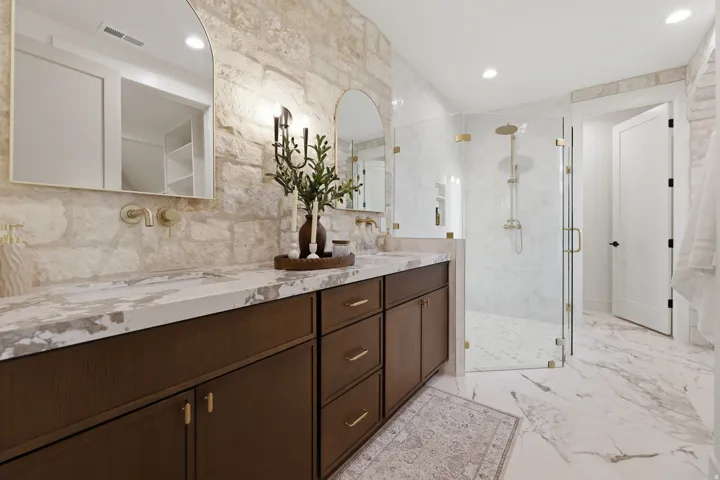 Double vanity with integrated sinks, stone-finish countertop, and wall-mounted faucets