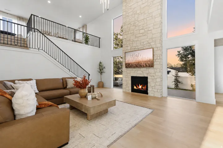 Two-story living area with a stone-clad fireplace and large windows