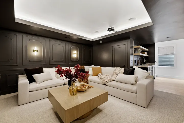 Wainscoted accent wall, recessed ceiling lighting, wall-mounted sconces, and a built-in wet bar with open shelving