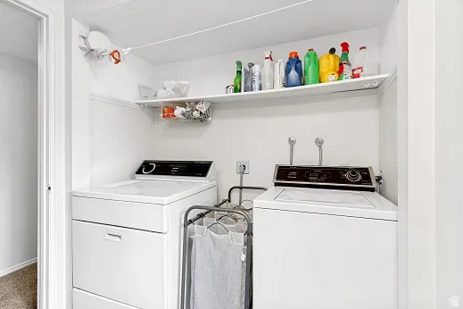 Built-in laundry appliances with a top-load washer and dryer, accompanied by a white storage shelf
