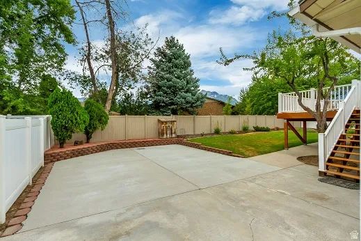 Spacious concrete pad with brick-edged retaining wall