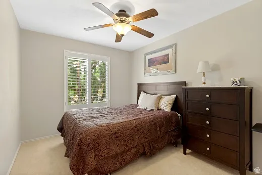 Bedroom with ceiling fan with integrated lighting, and neutral wall paint