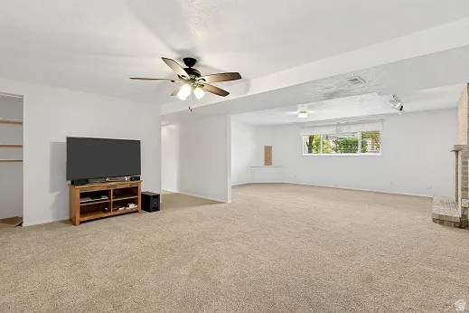 Expansive room with neutral carpeting and white walls