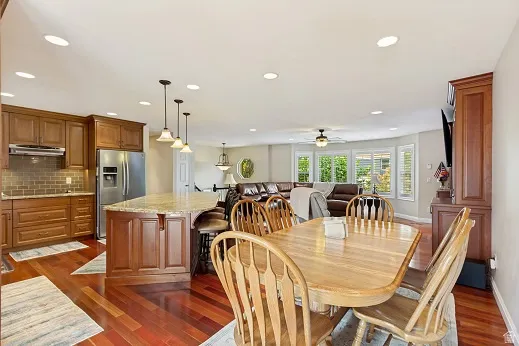 Brazilian Cherry hardwood flooring, recessed lighting, and a large kitchen island with pendant lighting