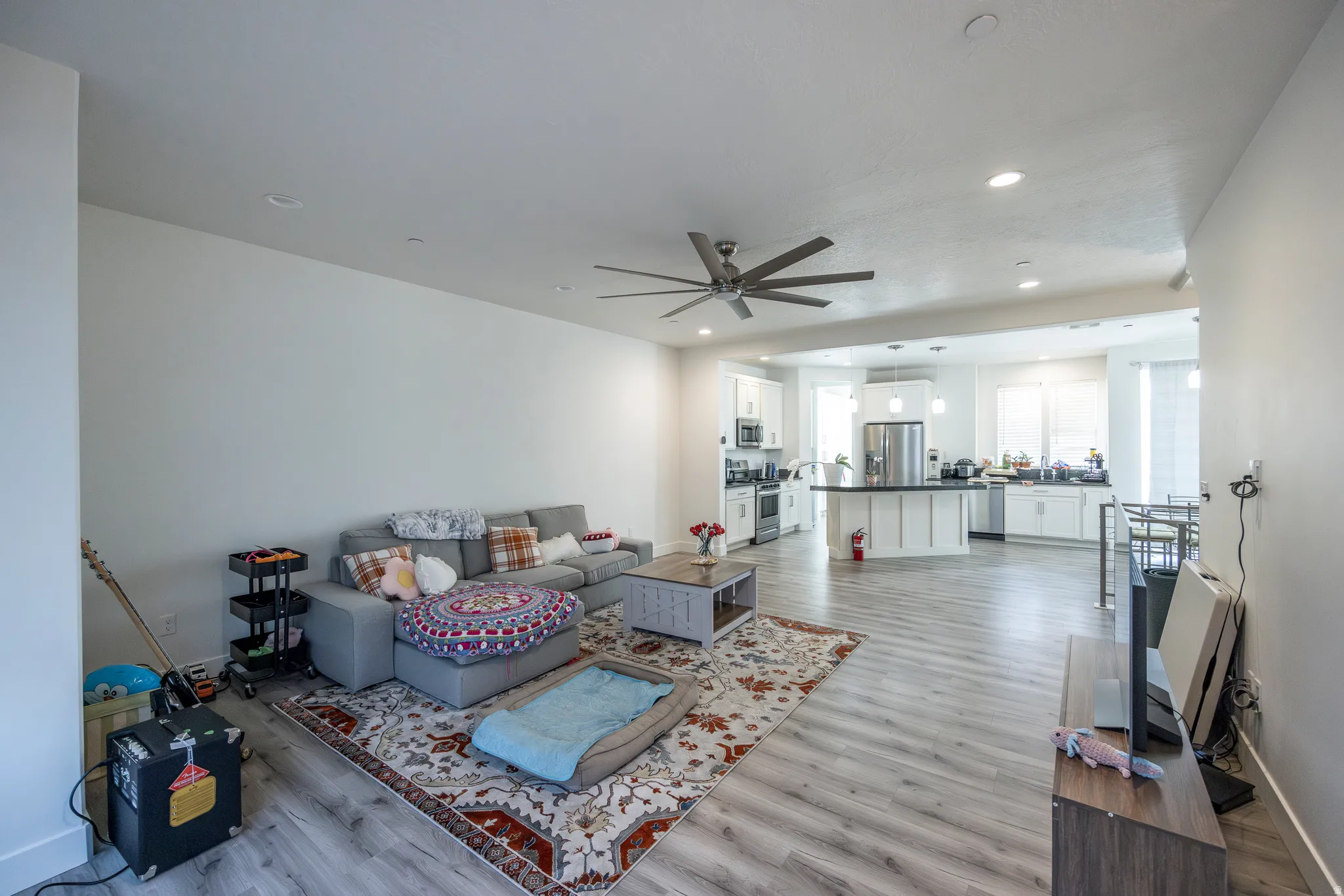 Open-concept living space featuring wood-finish flooring, recessed lighting, and a ceiling fan