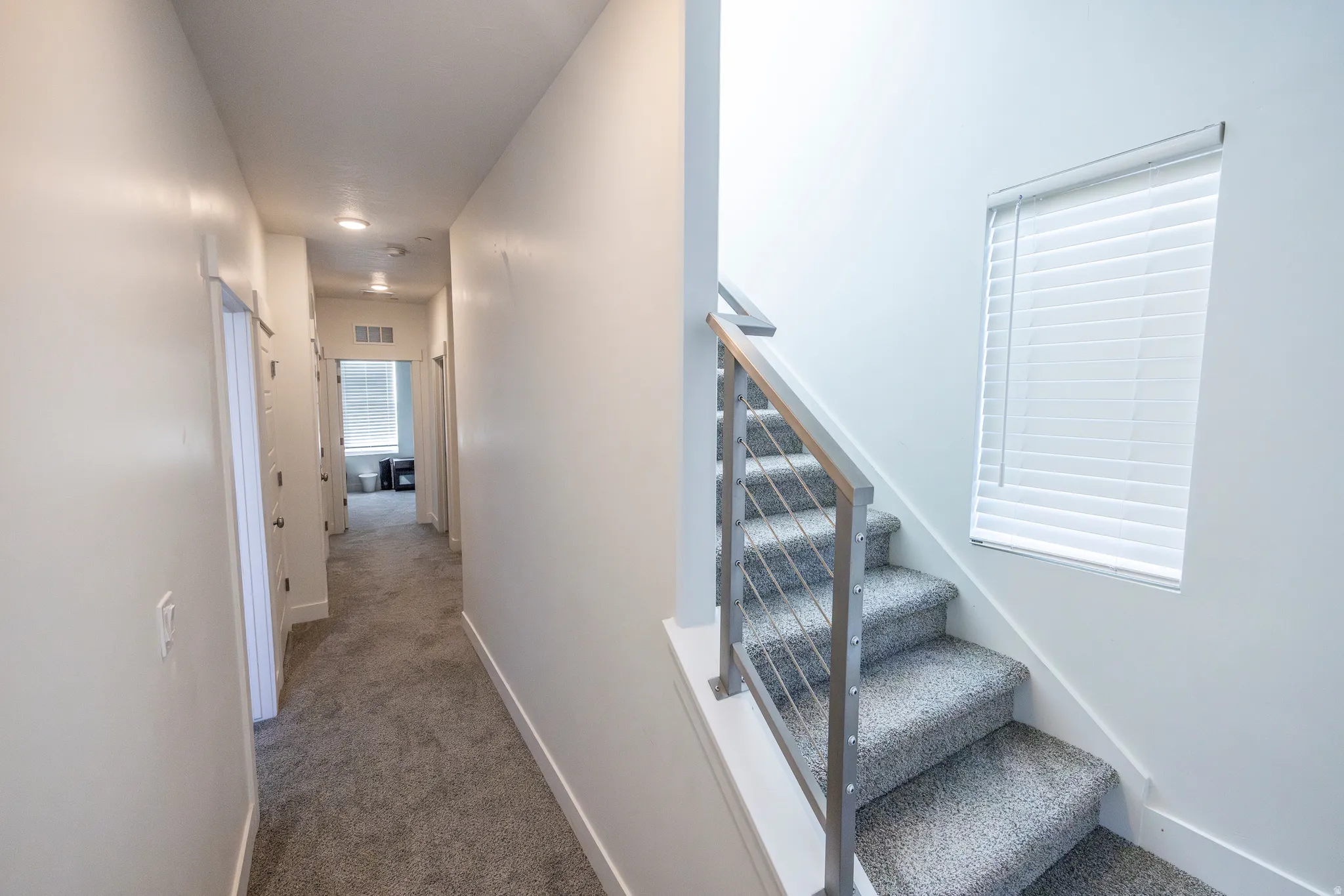 Carpeted staircase with contemporary metal railing