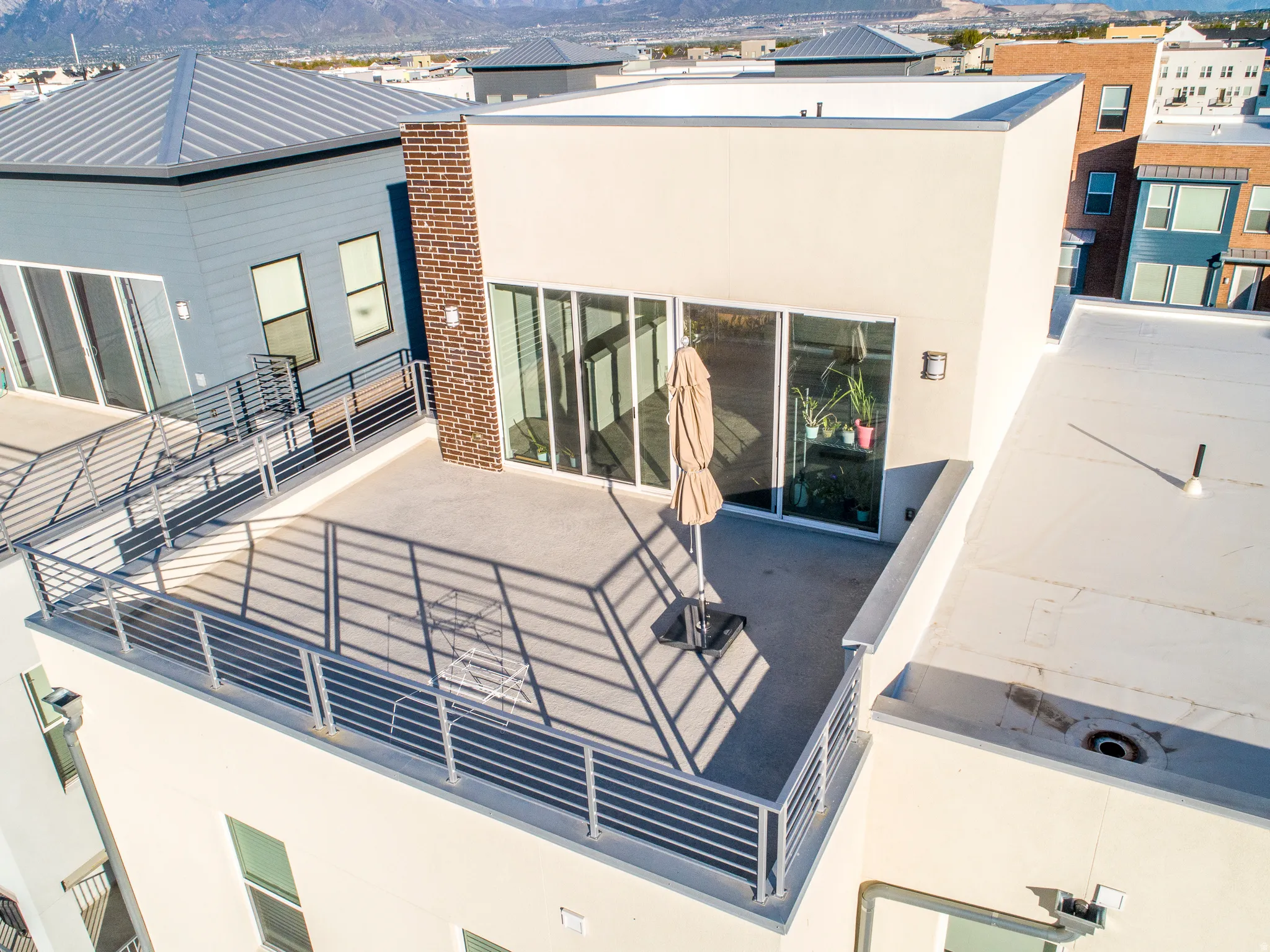 Rooftop deck featuring a metal railing, sliding glass door access, and an exterior light fixture