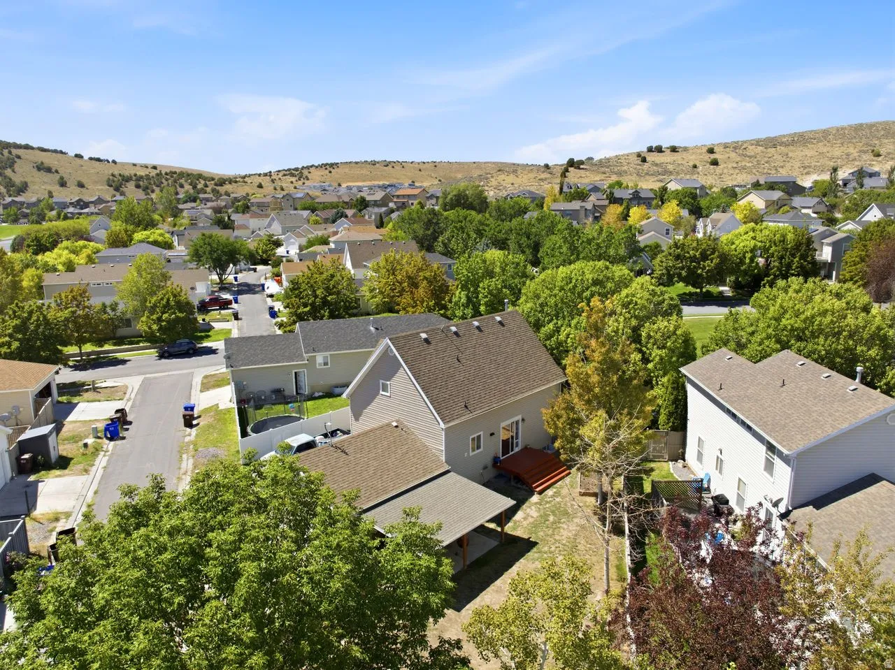 Hills surrounding a residential community with mature trees and paved streets