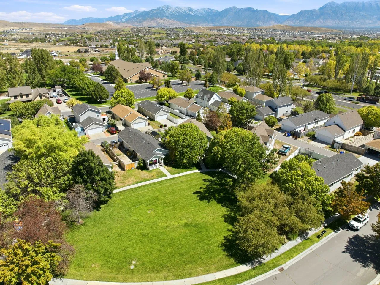 Expansive grassy lot with mature perimeter trees, offering a clear development opportunity