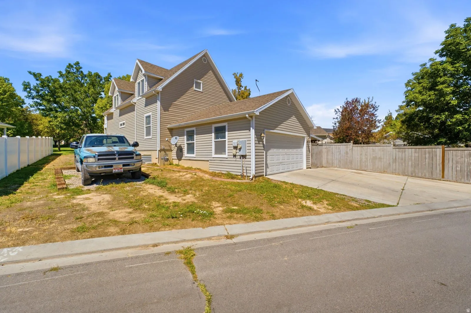 Two-story exterior with light-colored siding, attached garage, and a concrete driveway