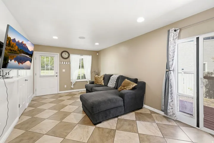 Diamond-pattern tile flooring, recessed ceiling lighting, a built-in white cabinet, and a sliding glass door with integrated blinds