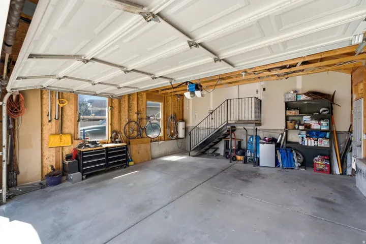 Garage featuring a metal staircase, concrete flooring, and multiple windows