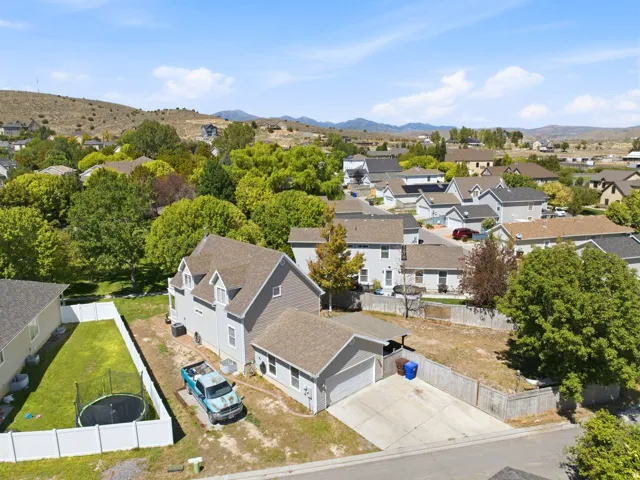 Two-story residence with a pitched roof, attached garage, and a fenced backyard