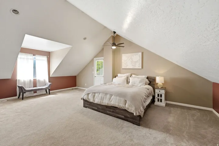 Sloped ceilings with recessed lighting, ceiling fan, and carpeted flooring