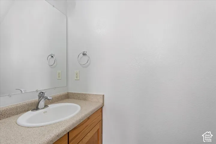 Built-in vanity with a laminate countertop, integrated sink, and chrome faucet