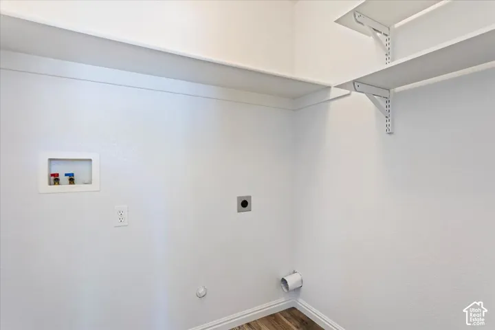 Utility connections and wall shelving, complemented by wood-finish flooring