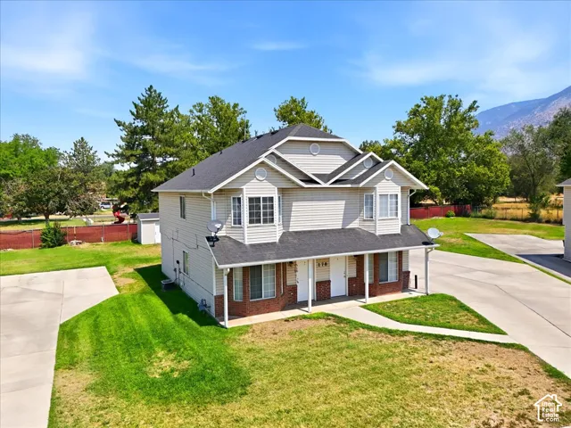 Two-story residence featuring light-colored siding and brick accents