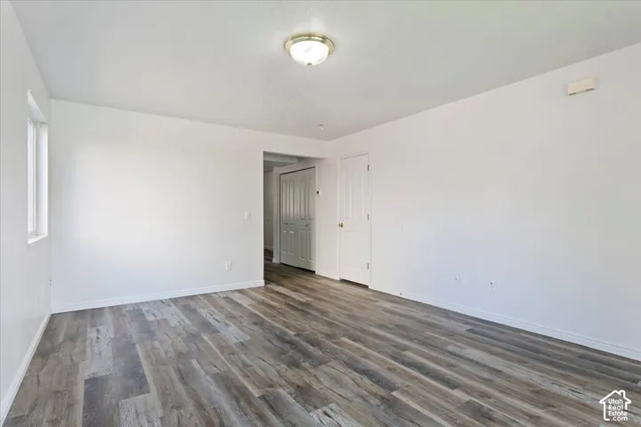 Wood-finish flooring, white walls, white ceiling, and a ceiling-mounted light fixture