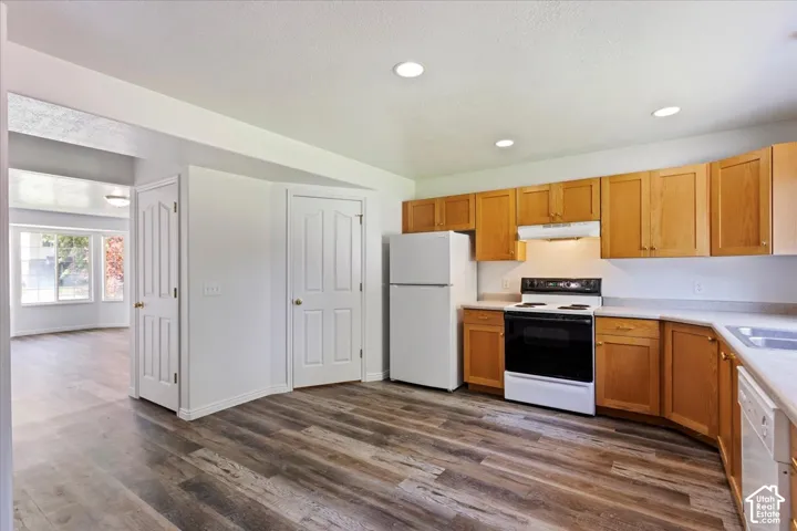 Kitchen featuring wood-finish flooring, recessed lighting, wood cabinetry, white countertops, and a full suite of appliances