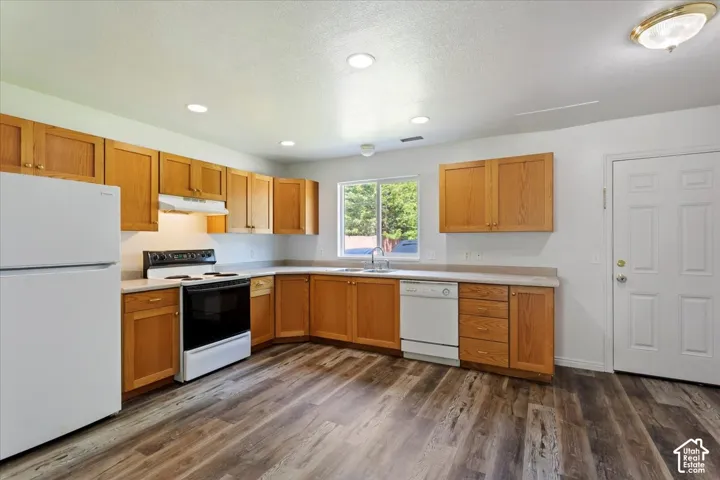 Kitchen featuring wood-finish flooring, recessed lighting, wood cabinetry, and a window above the sink