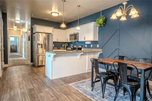 Kitchen with white cabinetry, stainless steel appliances, and a breakfast bar