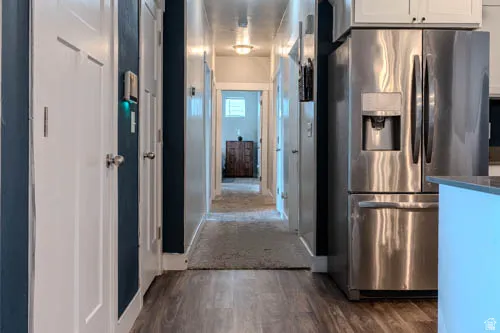 Wood-finish flooring leading to a hallway with carpet