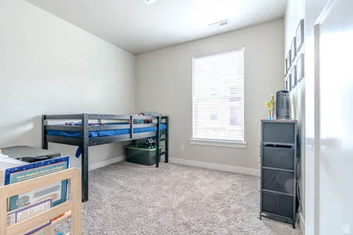 Window with blinds, wall-to-wall carpeting, and light-toned walls