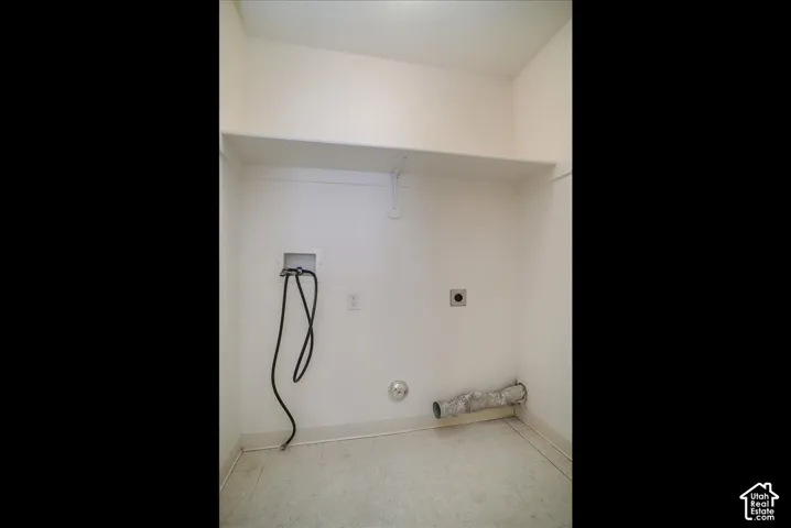 White painted walls with an overhead shelf and vinyl flooring