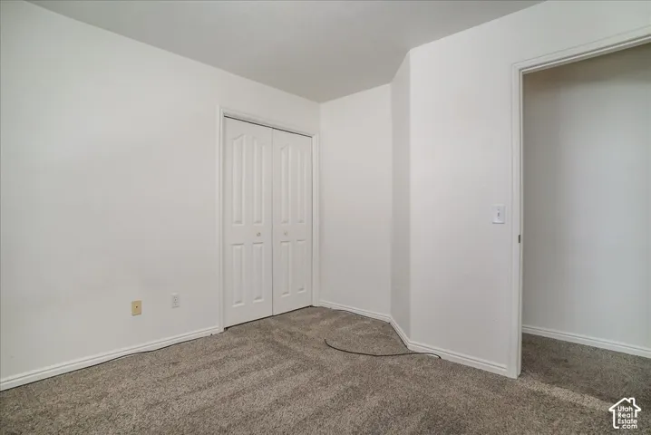 Neutral paint palette, textured carpet, and a bi-fold closet door