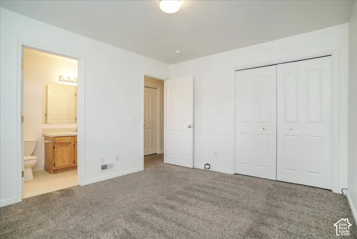 Plush gray carpeting, white walls, and a bi-fold closet