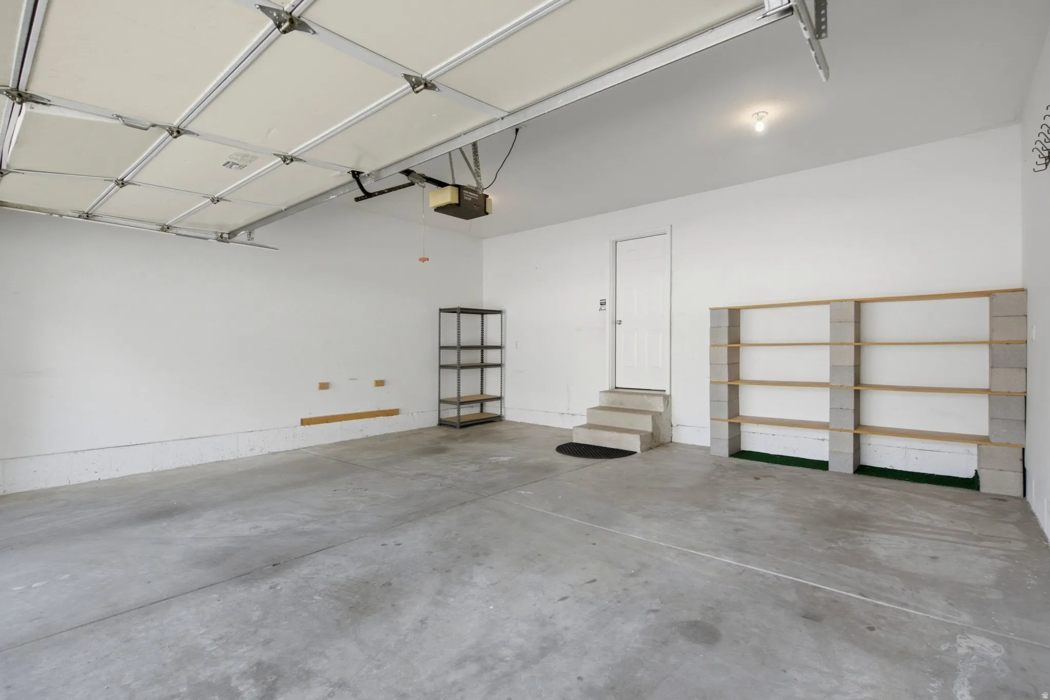 Concrete flooring, a finished ceiling, an interior door, and built-in shelving