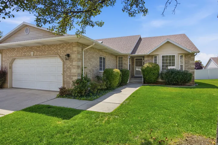 Brick exterior with siding accents, attached garage, concrete driveway, front walkway, and landscaped front yard