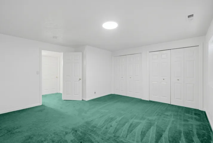 Green carpeting, white walls, and bright overhead lighting
