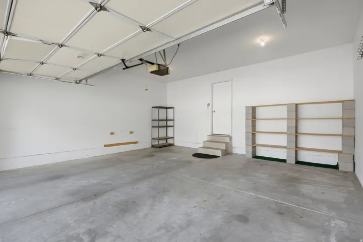 Concrete flooring, a finished ceiling, an interior door, and built-in shelving