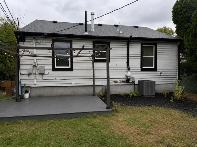 Rear exterior featuring a gray composite deck, light-colored horizontal siding, and a dark shingle roof