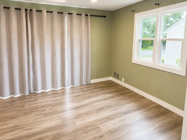 Wood-finish flooring, recessed lighting, and a white-trimmed window with exterior views