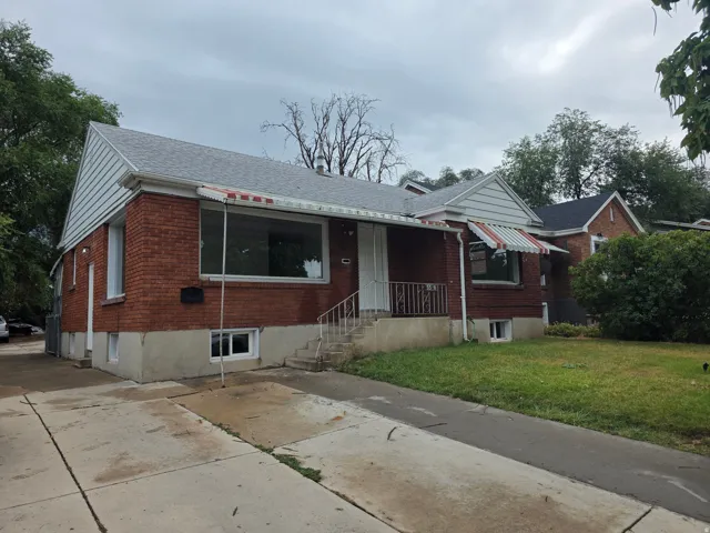 Brick exterior with white siding accents and a gray shingle roof