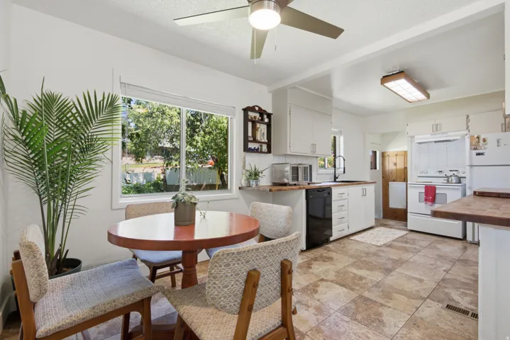 Freshly painted walls and cabinetry with new butcher block countertops, and tile flooring.