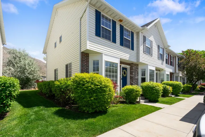 Townhome exterior with light-colored siding and dark shutters