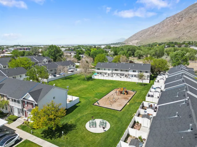 Expansive green space featuring a playground, communal seating area, and established landscaping