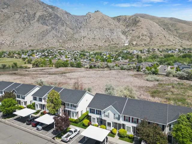 Townhome community with mountain backdrop, individual covered parking, and landscaped grounds