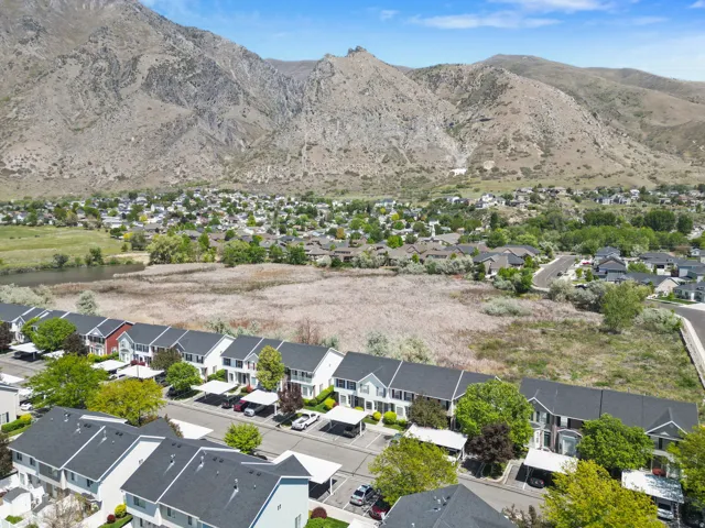 Row of multi-story townhomes with dark shingle roofs and varying exterior colors