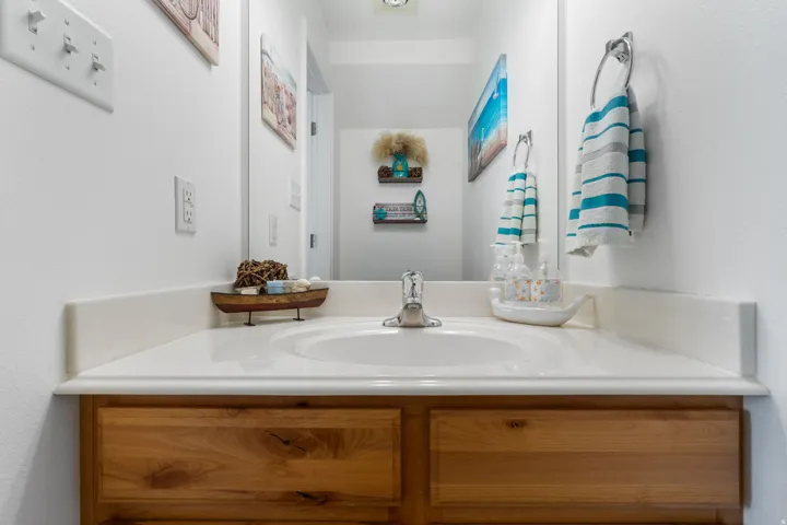 Built-in vanity with a light wood-finish cabinet and an integrated sink, featuring a chrome faucet